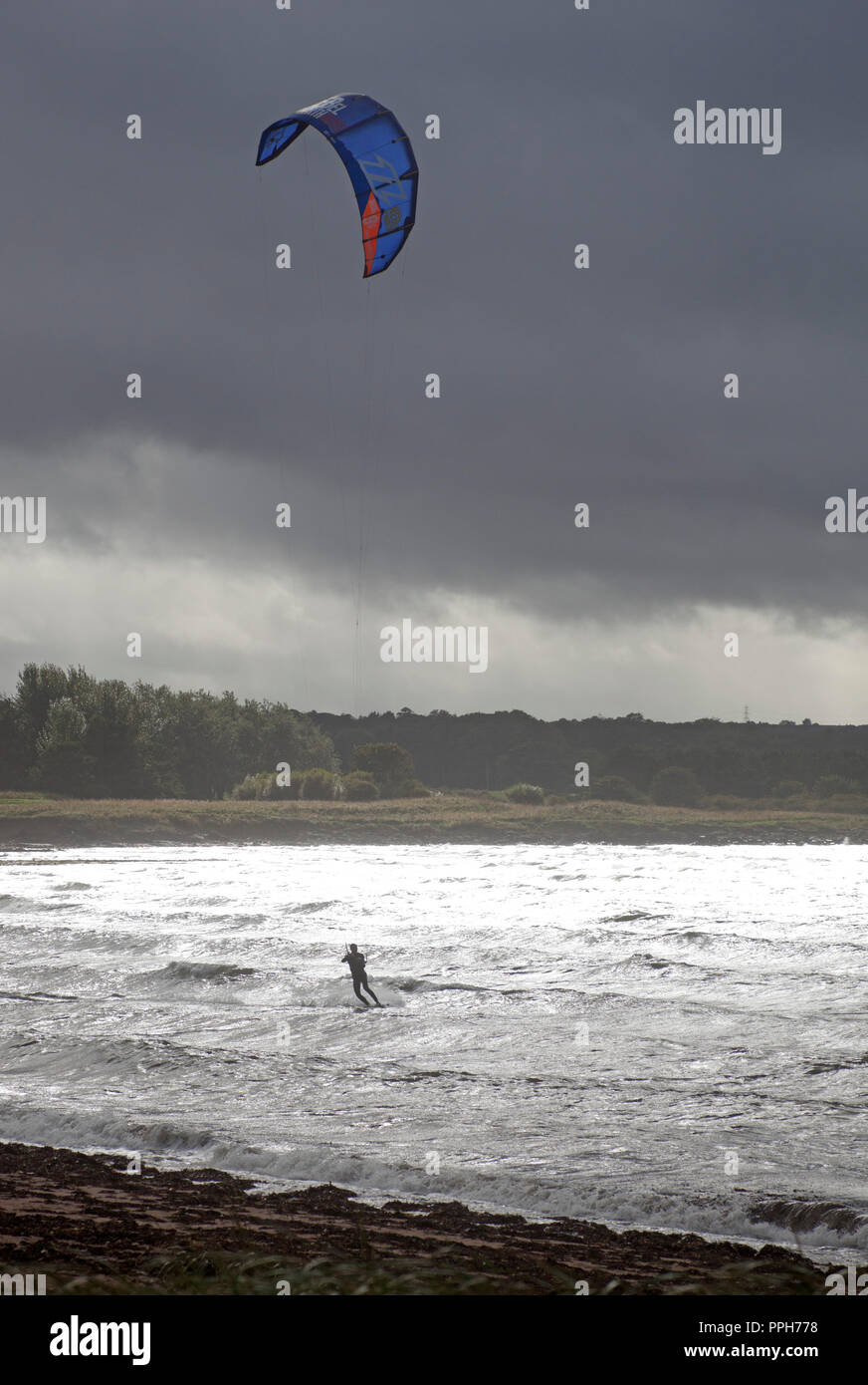 East Lothian, Scotland, UK weather, 26 September 2018. Testing conditions for Kitesurfer and windsurfer at Longniddry Bents, afternoon temperature of 18 degrees and wind with estimated gusts of 39km/h together with squally showers, and Arthur's Seat and the city of Edinburgh in the background. Stock Photo