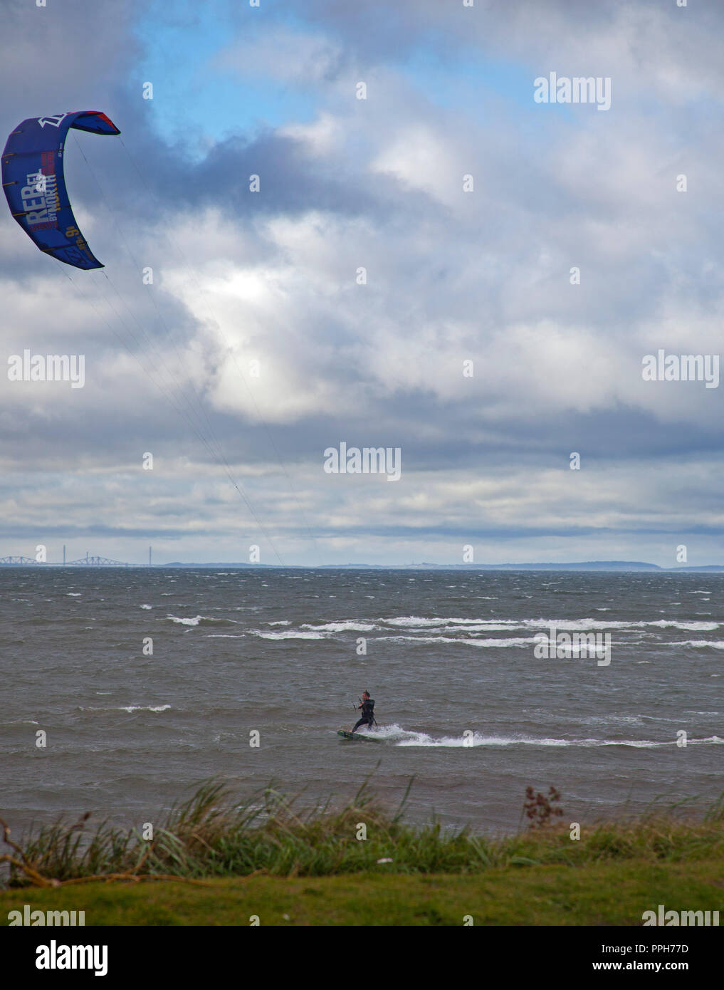 East Lothian, Scotland, UK weather, 26 September 2018. Testing conditions for Kitesurfer and windsurfer at Longniddry Bents, afternoon temperature of 18 degrees and wind with estimated gusts of 39km/h together with squally showers, and Arthur's Seat and the city of Edinburgh in the background. Stock Photo