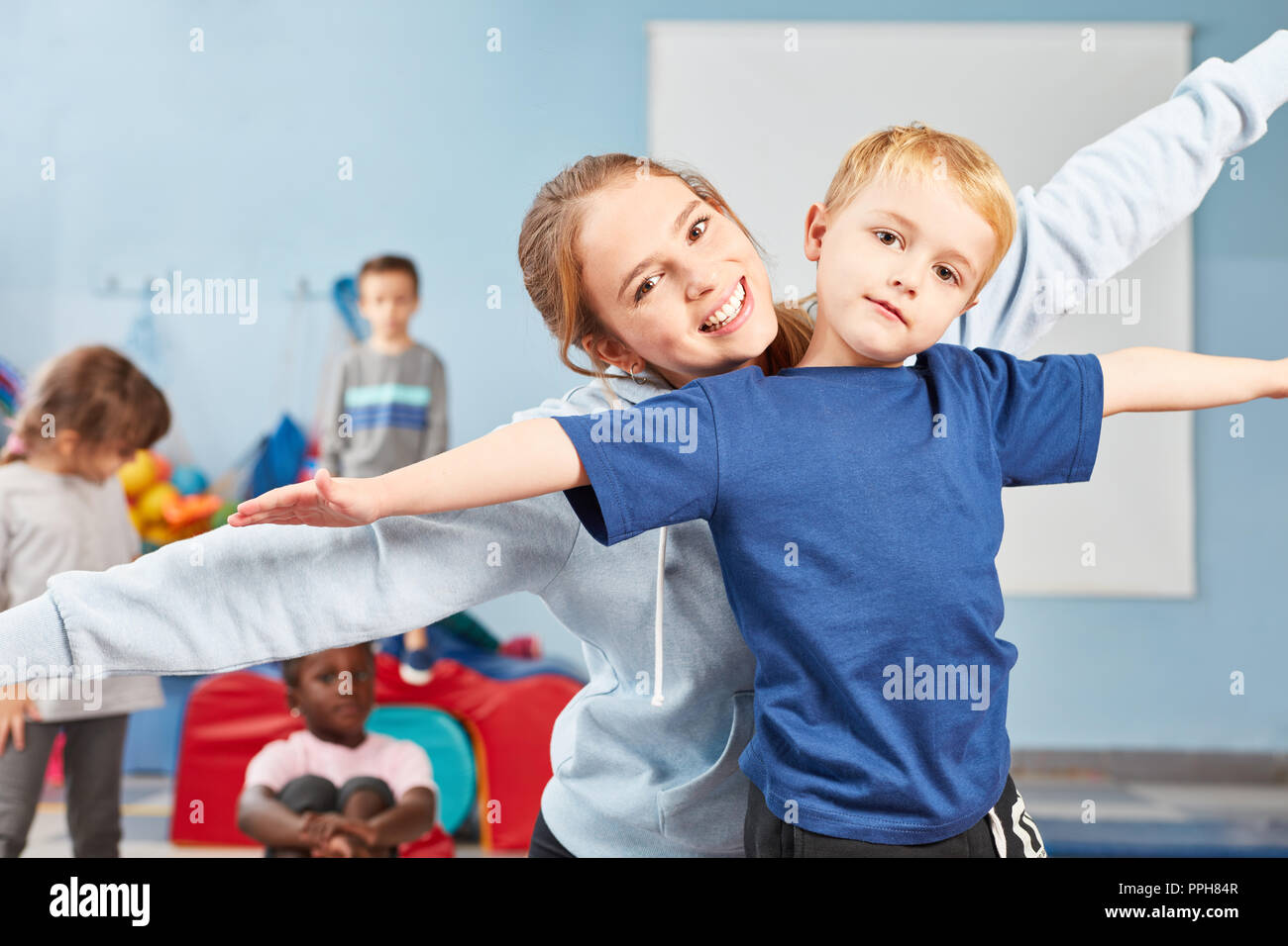 Boy doing stretching exercise together with wife as a teacher or sports teacher Stock Photo