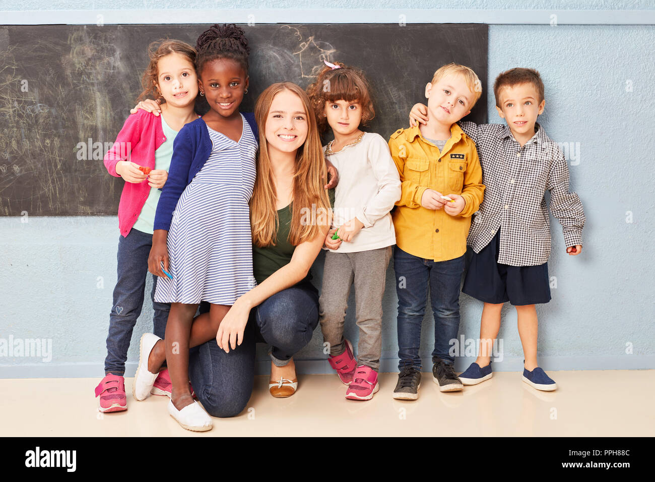 Group of children and teacher as friends together in preschool or kindergarten Stock Photo