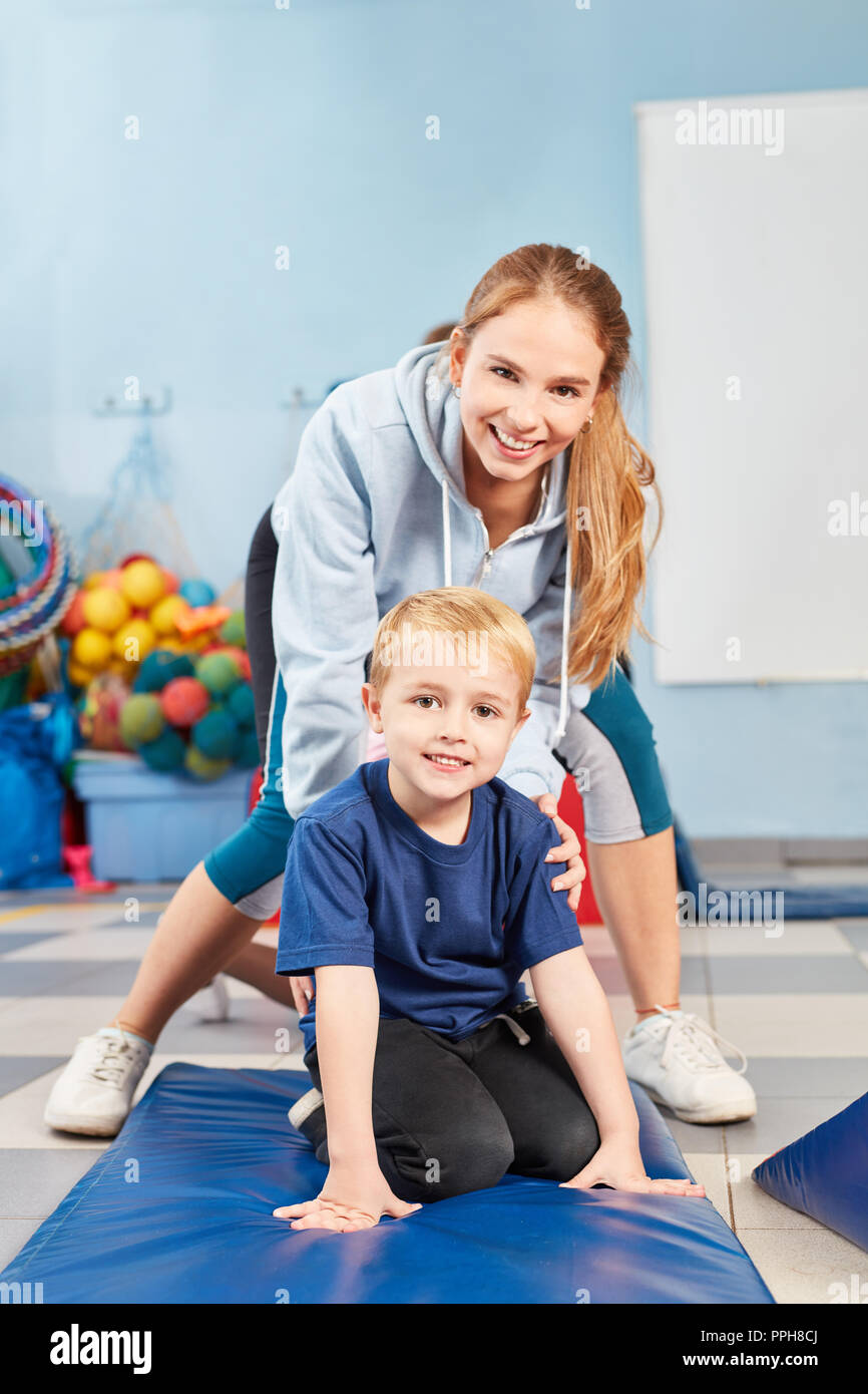 Young and sports teacher together in kids gymnastics in the gym in kindergarten Stock Photo