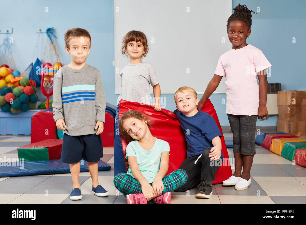 Multicultural children as friends in the gym in kindergarten or preschool Stock Photo