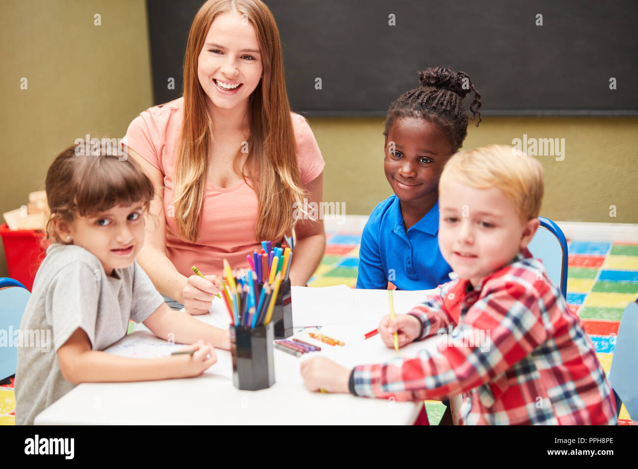 Children and kindergarten teachers in the drawing course paint together