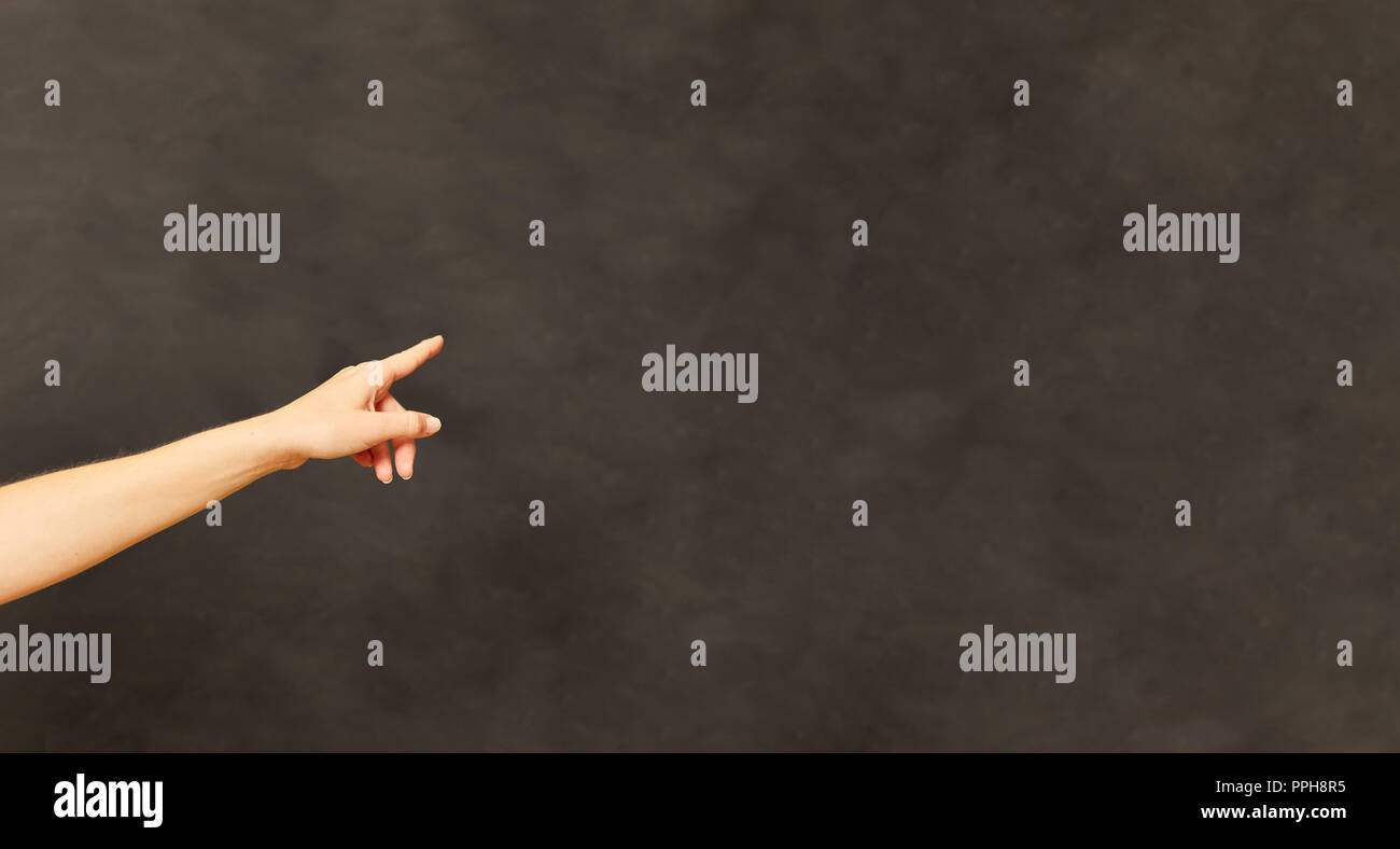 Hand of a teacher pointing to a blank blackboard in the school Stock Photo