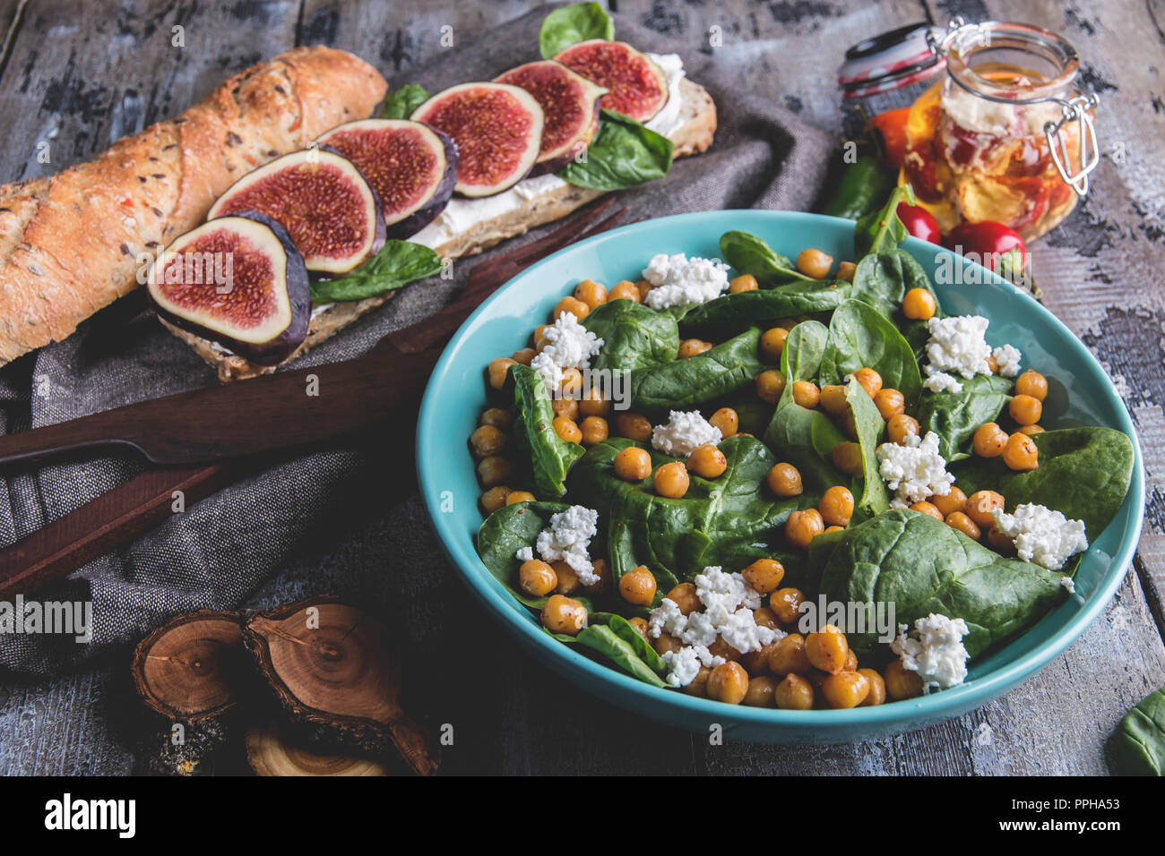 Chickpea and veggies salad with spinach leaves, homemade cheese,healthy vegan food,sandwich with figs, diet dish Stock Photo