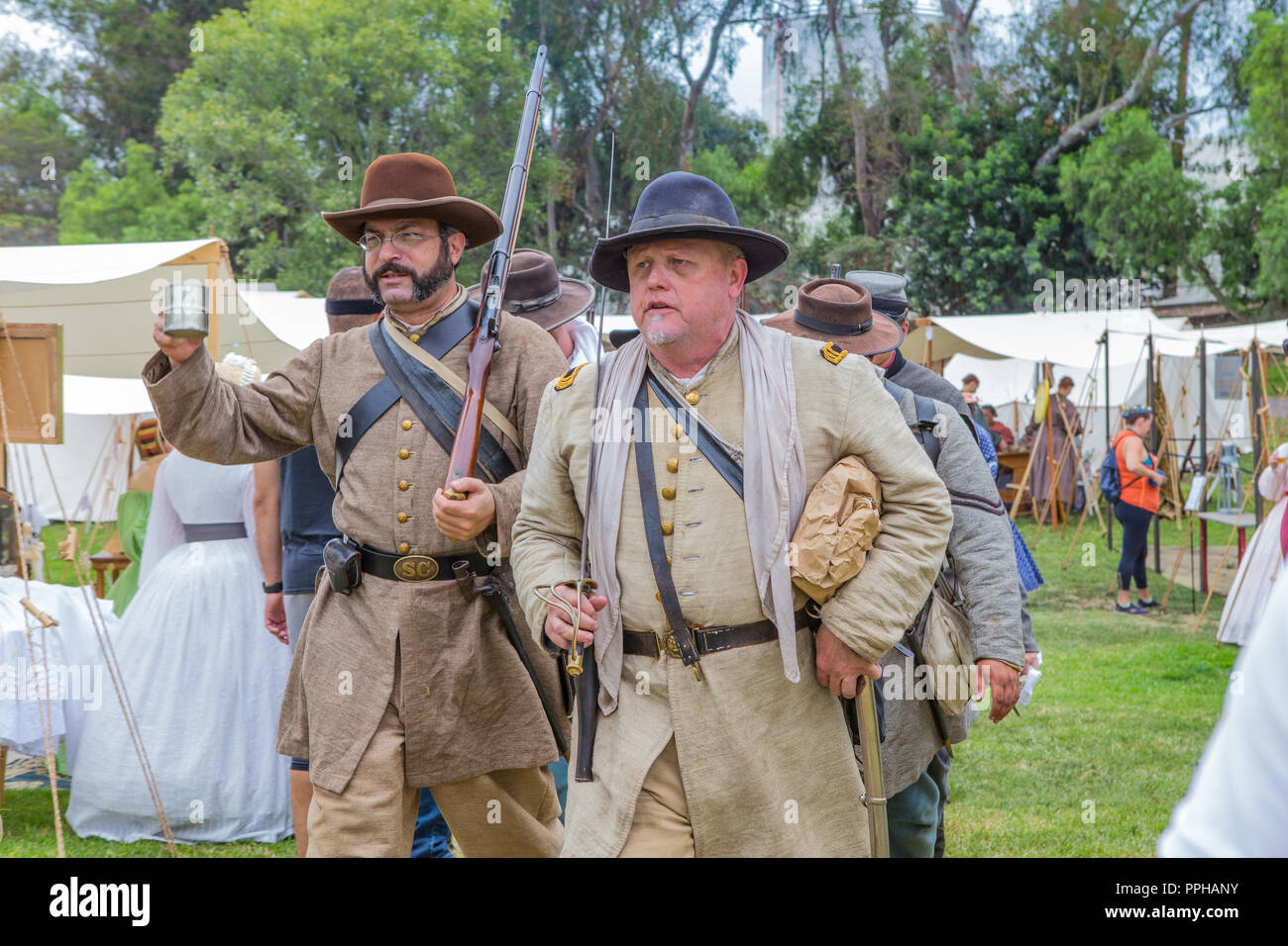 Confederate soldiers walk through an encampment during an American