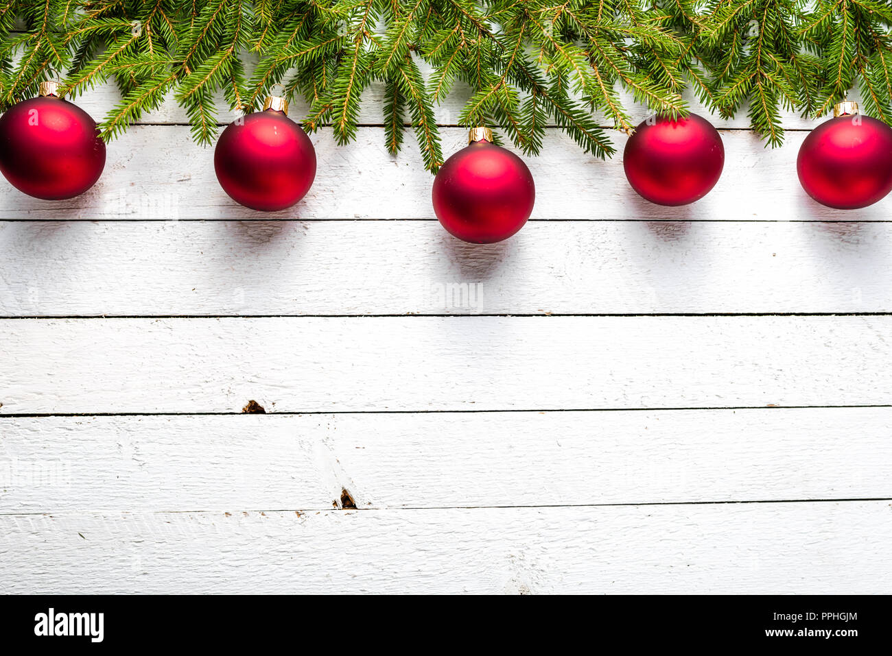 Christmas background with red balls on fir branches on wooden white ...