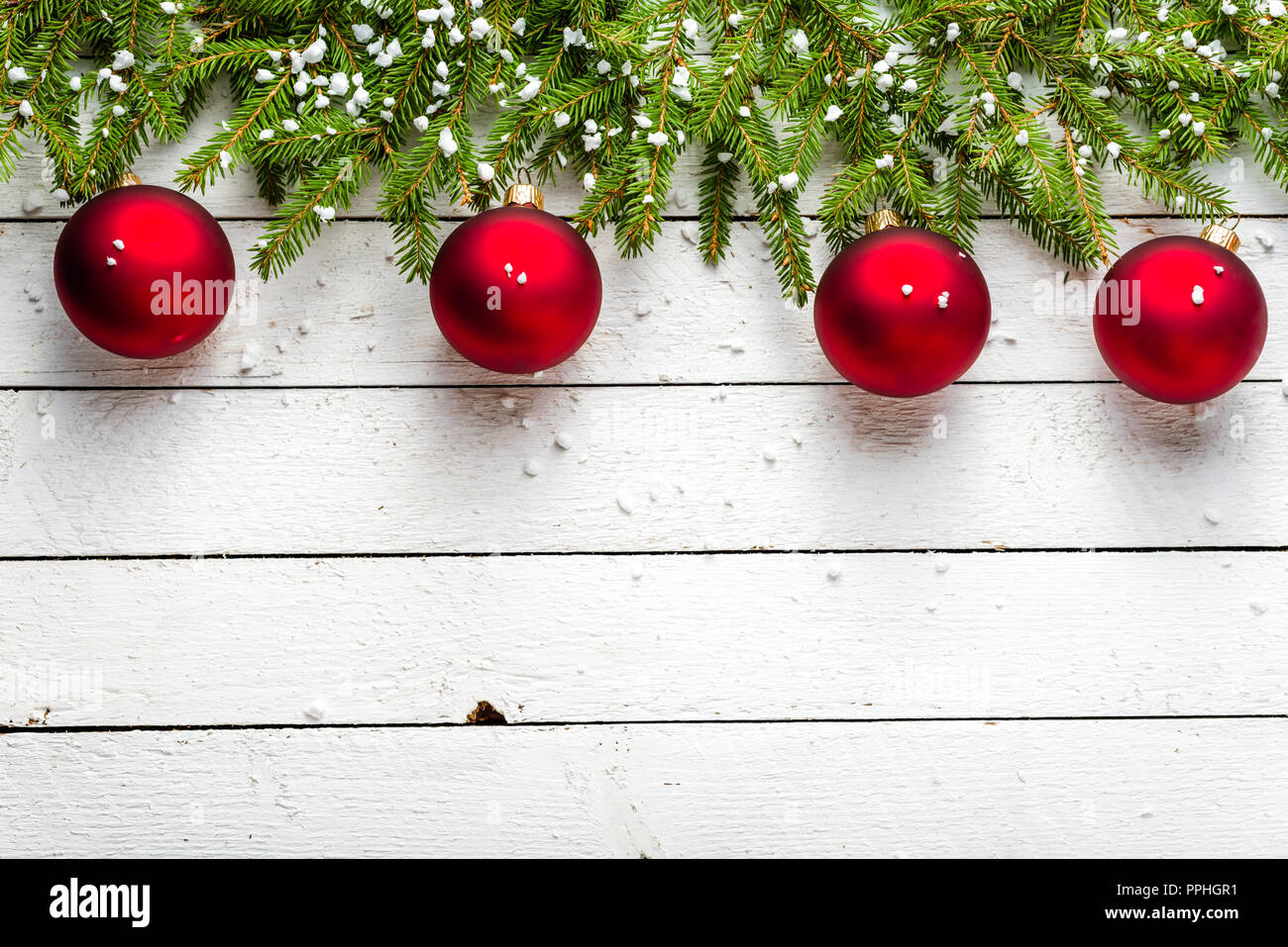 Festive christmas border with red balls on fir branches and snowflakes ...