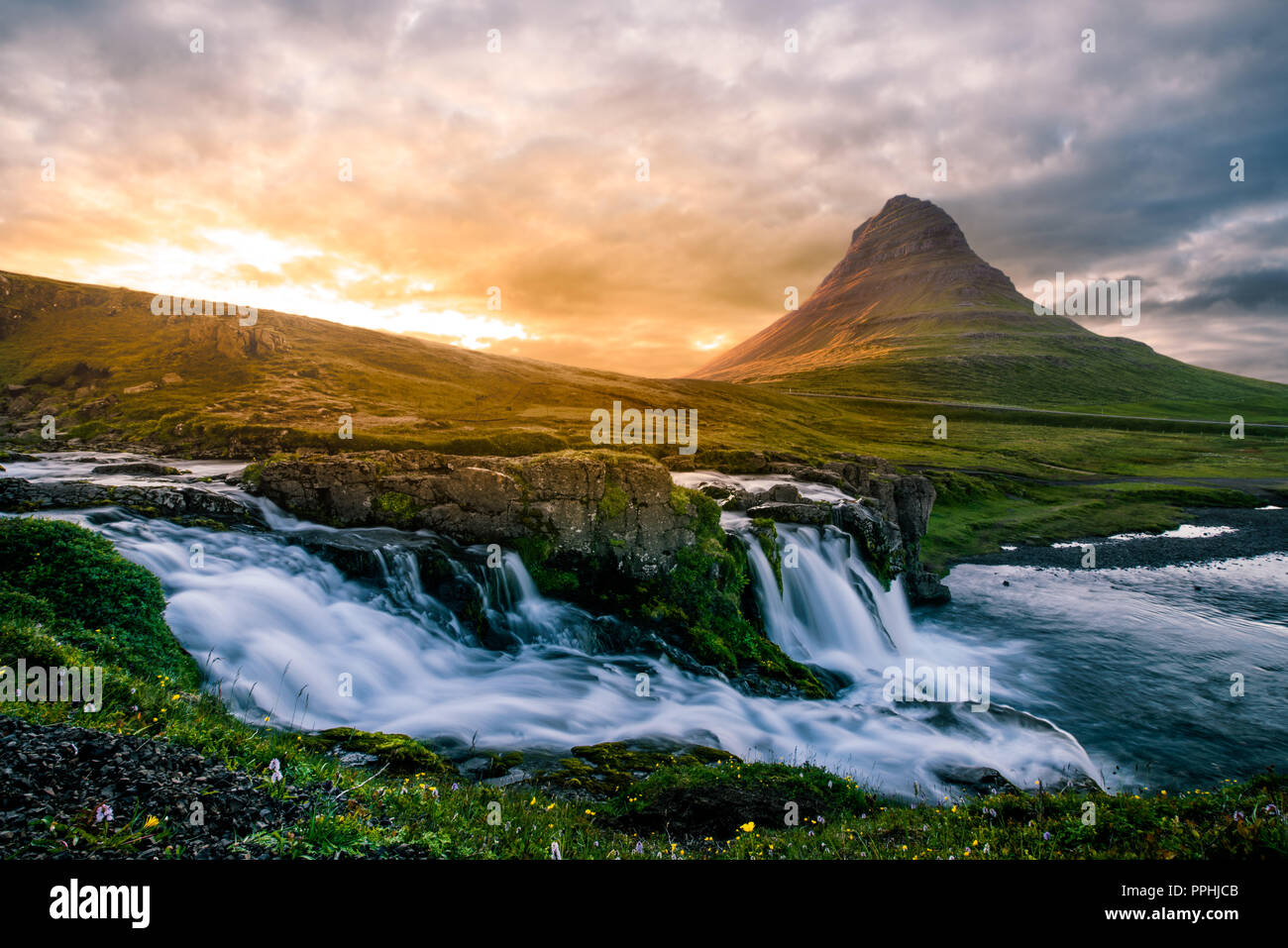 Wide long exposure of Iceland scenery with waterfall and hill Stock Photo