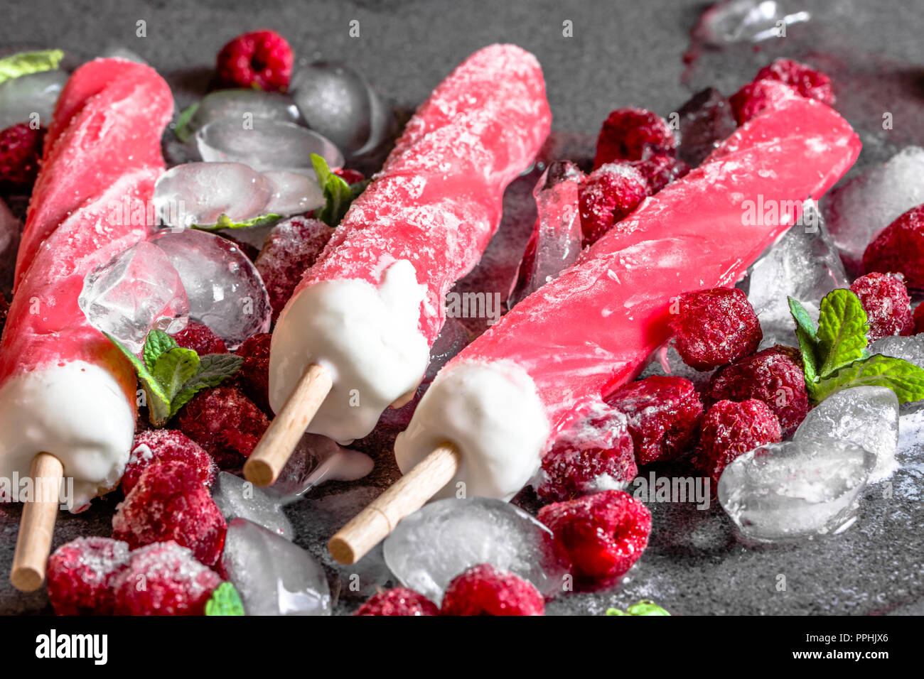 Raspberry popsicles on ice with frozen fruits sorbet, sweet summer