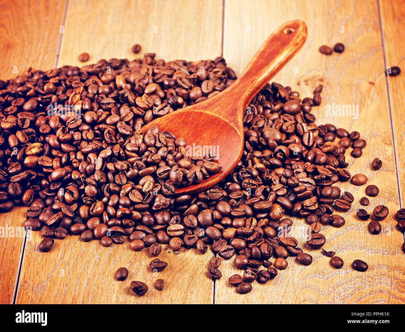 wooden spoon with coffee beans on table Stock Photo - Alamy