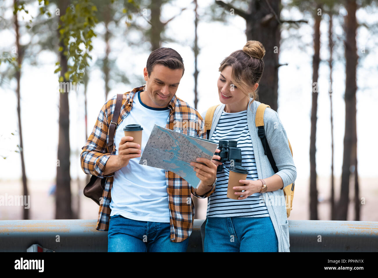portrait of smiling couple looking at map while traveling together Stock Photo