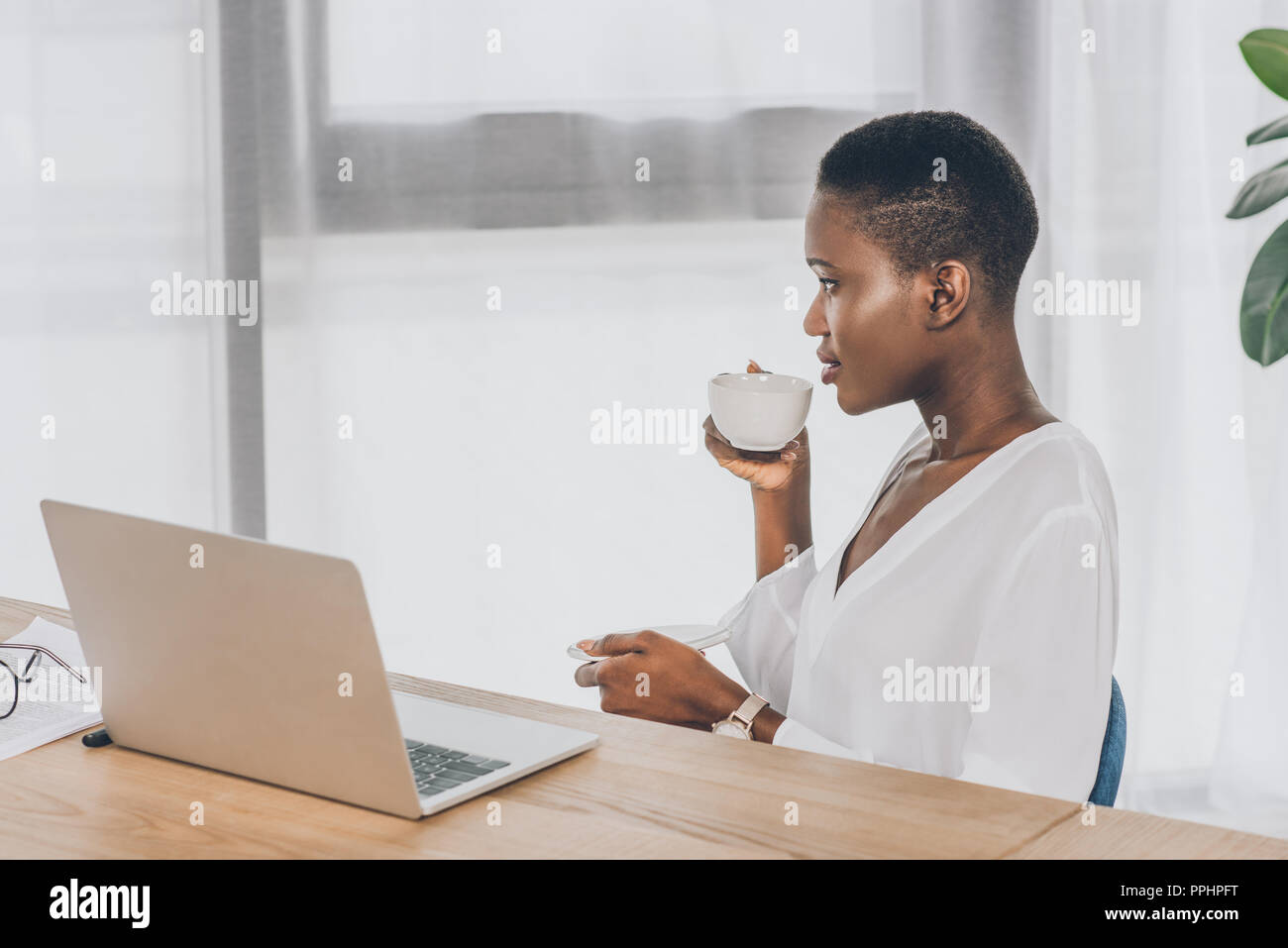 side view of stylish attractive african american businesswoman drinking ...