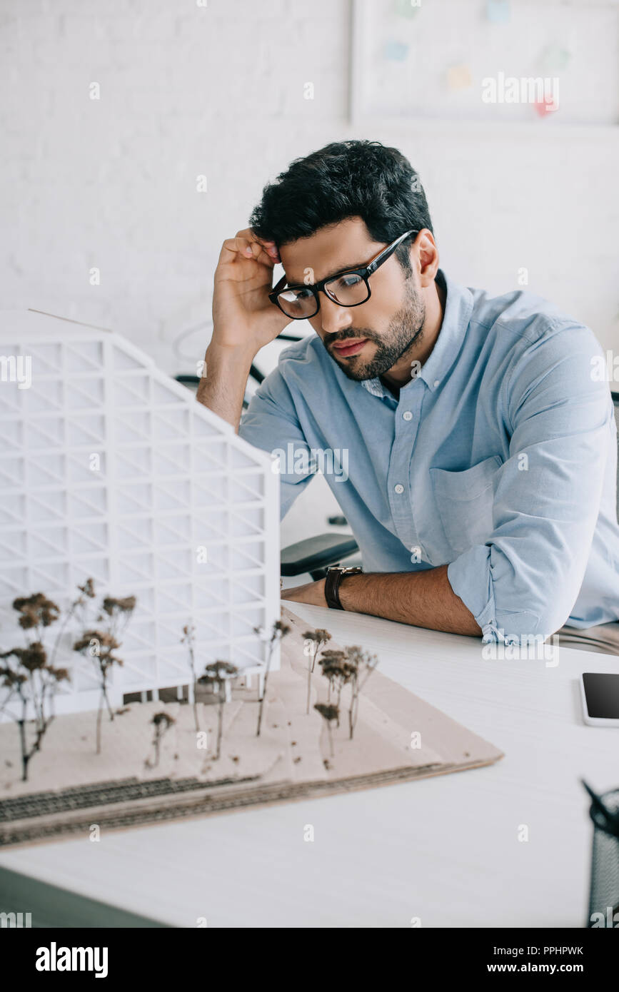 upset architect looking at architecture model in office Stock Photo