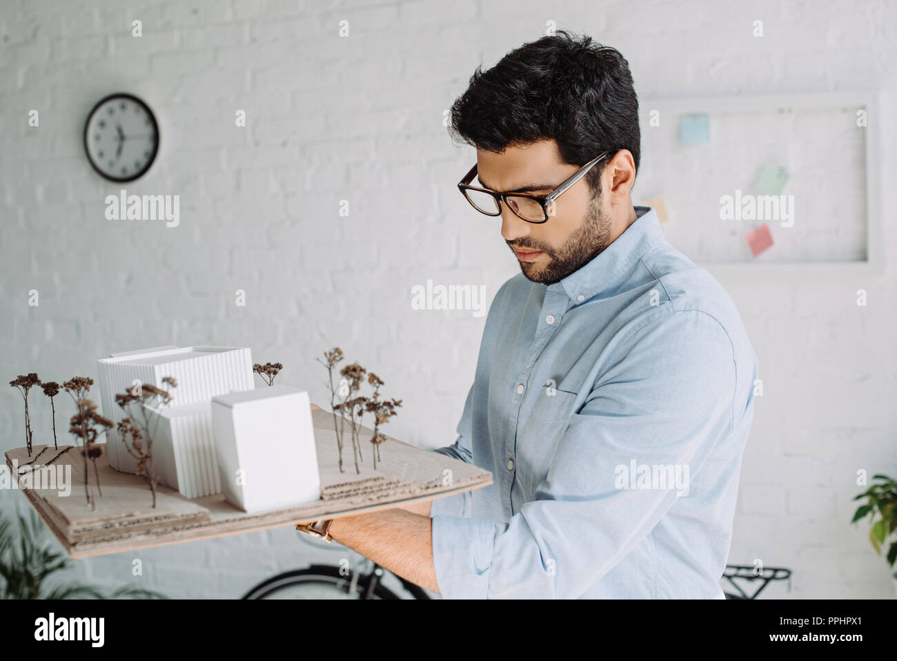 handsome architect in glasses looking at architecture model in office Stock Photo