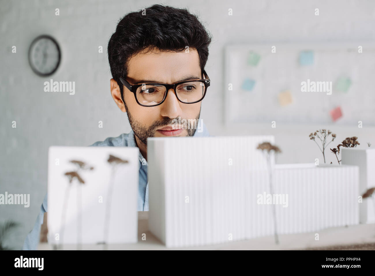 handsome brunette architect in glasses looking at architecture model in office Stock Photo