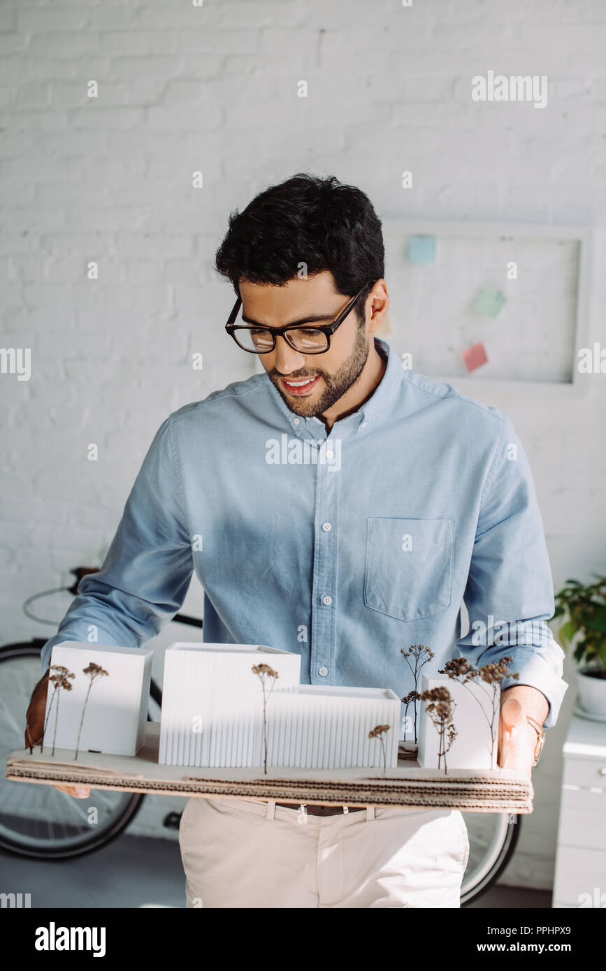 handsome smiling architect holding architecture model in office Stock Photo