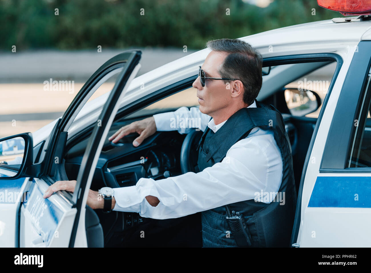 side view of middle aged male police officer in bulletproof vest and ...