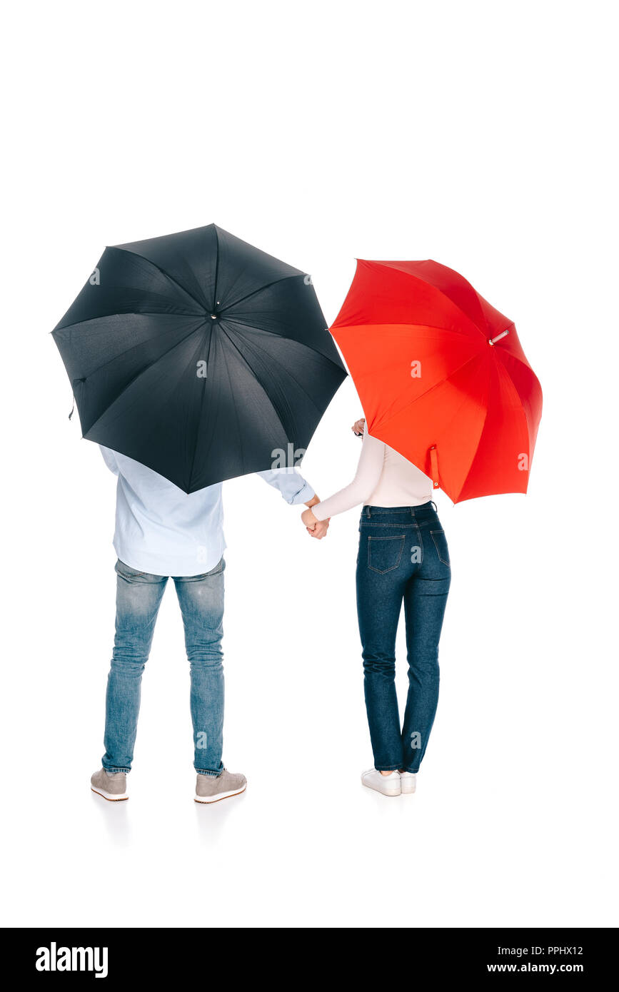 back view of young couple with black and red umbrellas holding hands