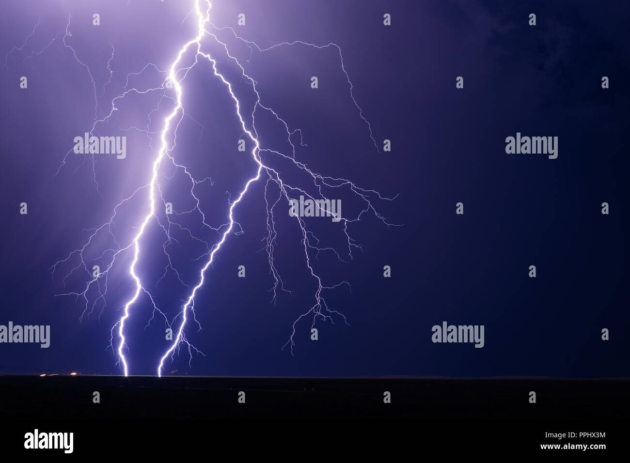 Lightning bolts strike from a thunderstorm in the night sky near Willcox, Arizona Stock Photo