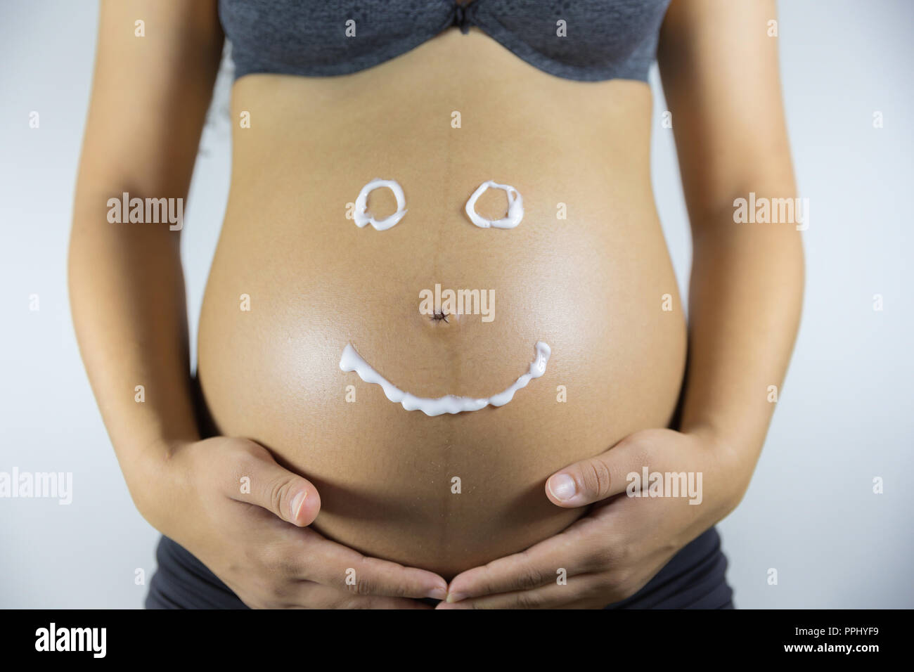 Pregnancy and skin care. Belly of pregnant woman and smile from