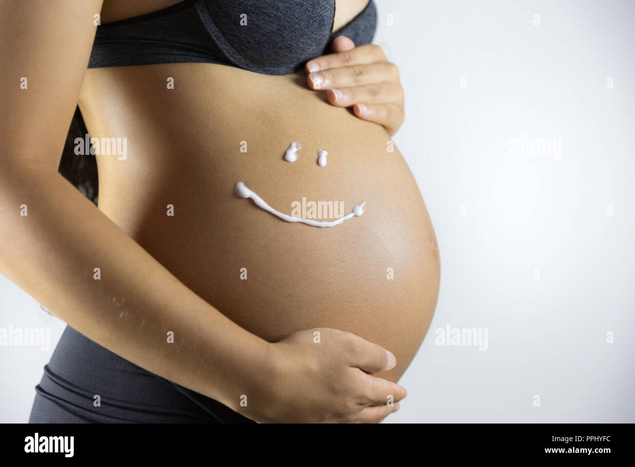 Pregnancy and skin care. Belly of pregnant woman and smile from