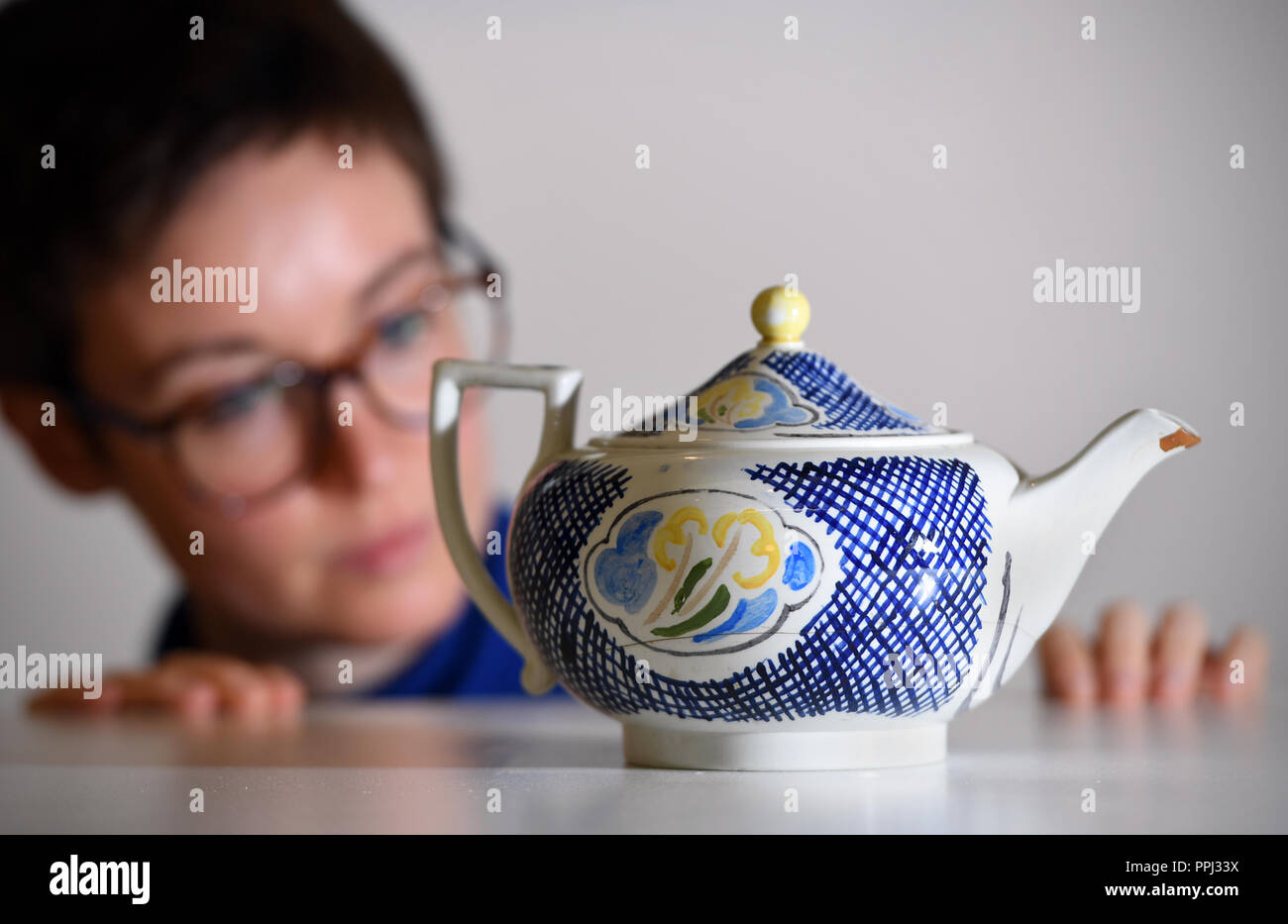 Conservator Flavia Ravaioli inspects a Wedgwood teapot used by Virginia Woolf and hand-decorated by her sister Vanessa Bell, at the Fitzwilliam Museum in Cambridge, where an exhibition inspired by the celebrated author and feminist's writings opens on October 2. Stock Photo