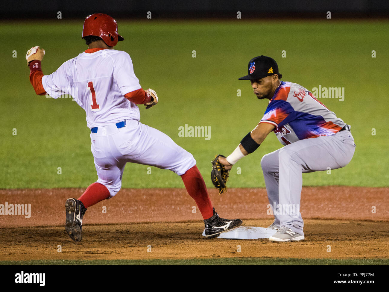 Roel Santos de Alazanes de Gamma de Cuba, regresa a tiempo con el segunda base Gustavo Nunez en un revire del pitcher Yunesky Maya de Águilas Cibaeñas Stock Photo