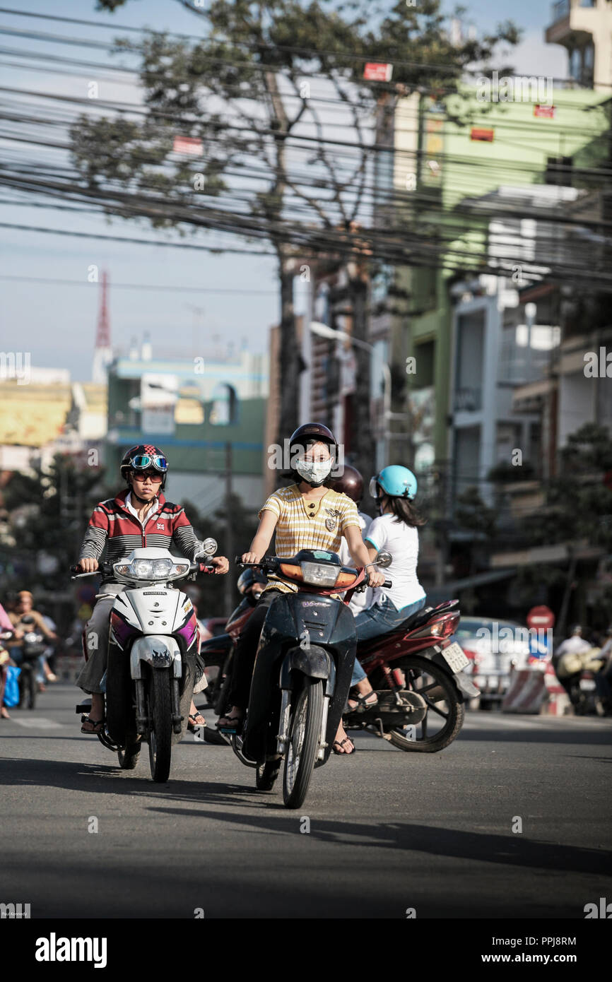 Woman riding motorcycle with protective face mask in Ho Chi Minh City, Vietnam Stock Photo