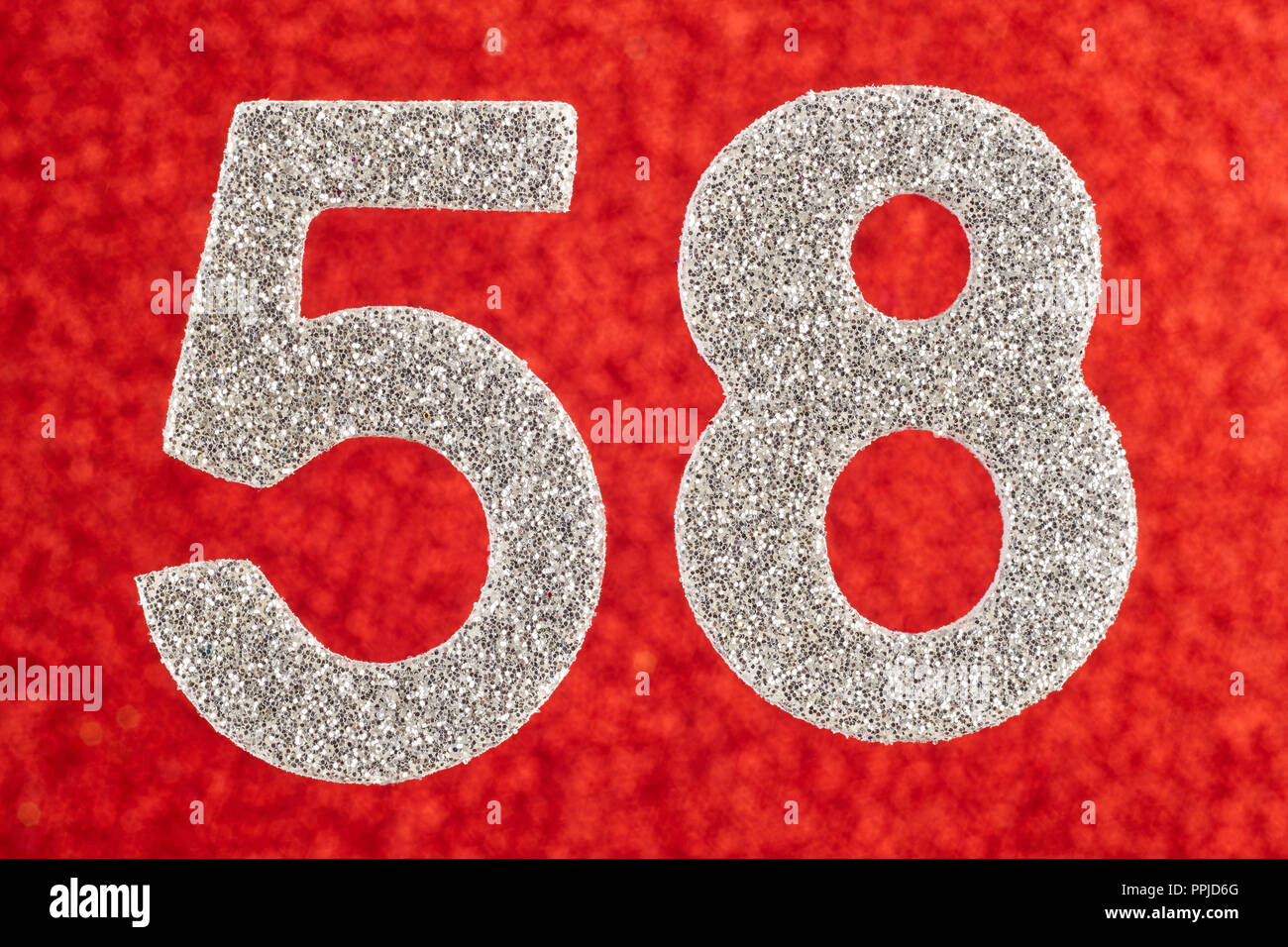 Number fifty-eight silver color over a red background. Anniversary. Horizontal Stock Photo