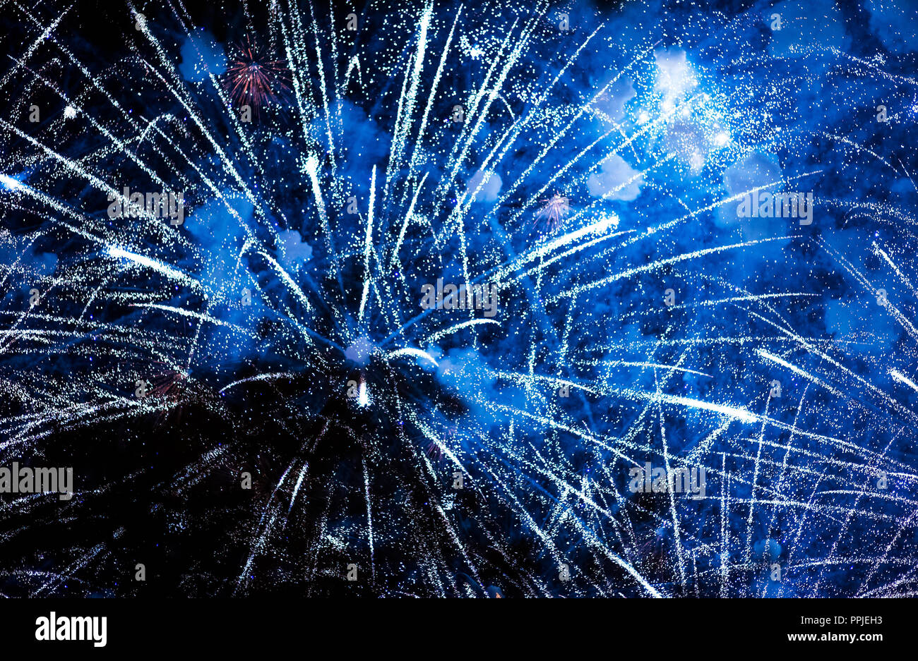 Salute in the night sky. Bright texture of festive fireworks. Abstract holiday background with various colors fireworks light. New Year's, Christmas l Stock Photo