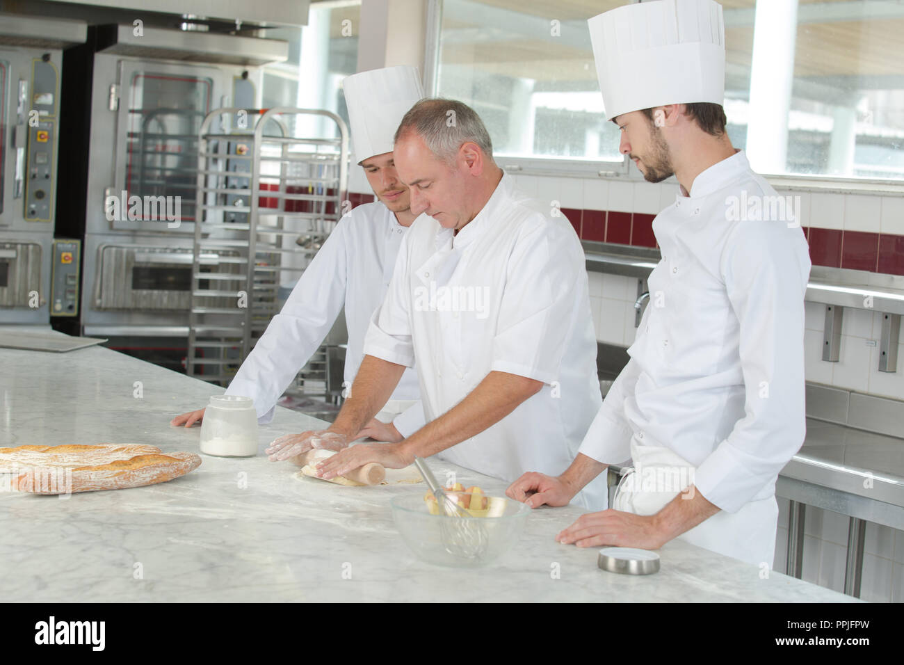 baker and assistants in a bakery kitchen Stock Photo Alamy