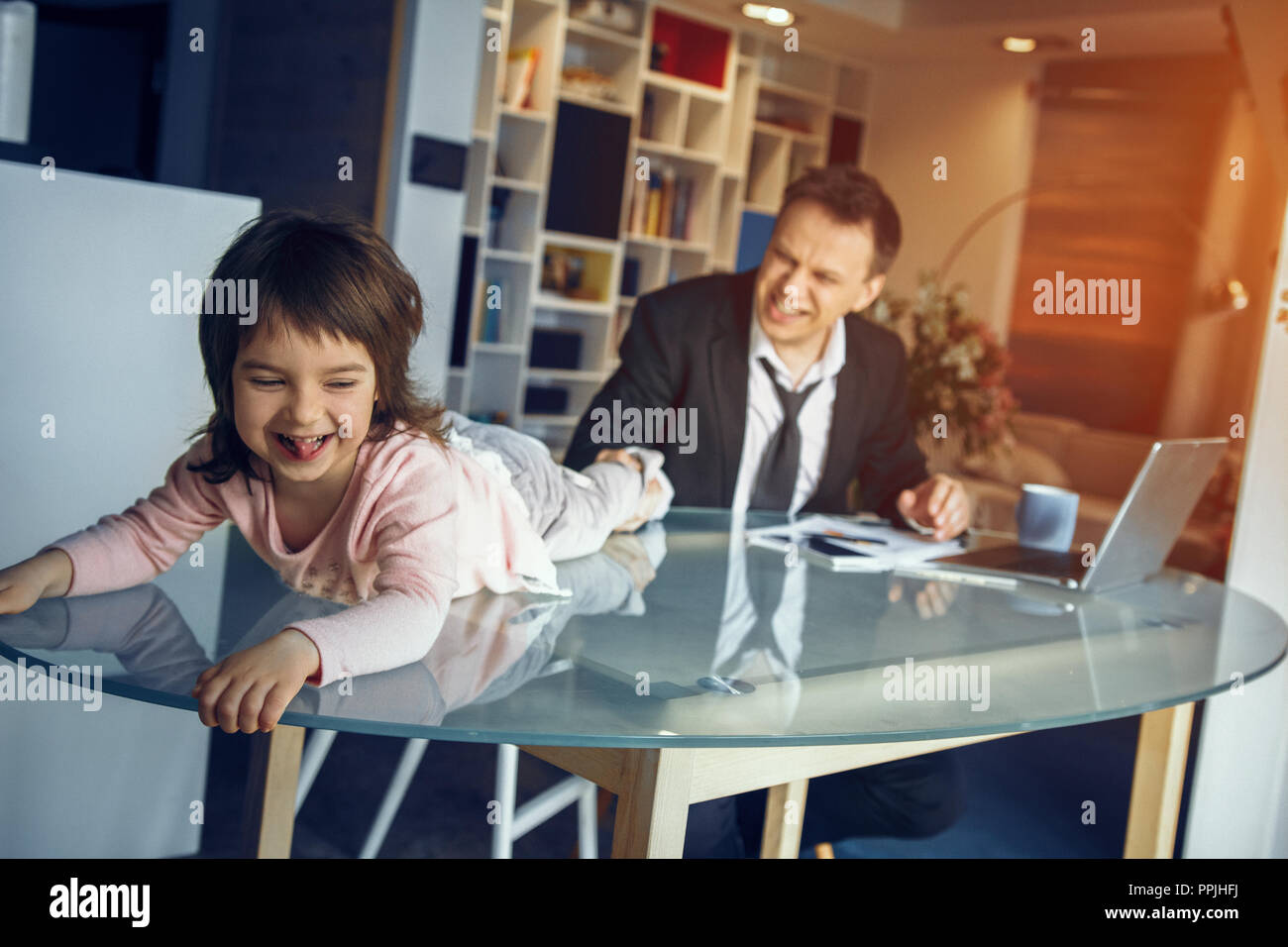 Daughter helping father working at home Stock Photo