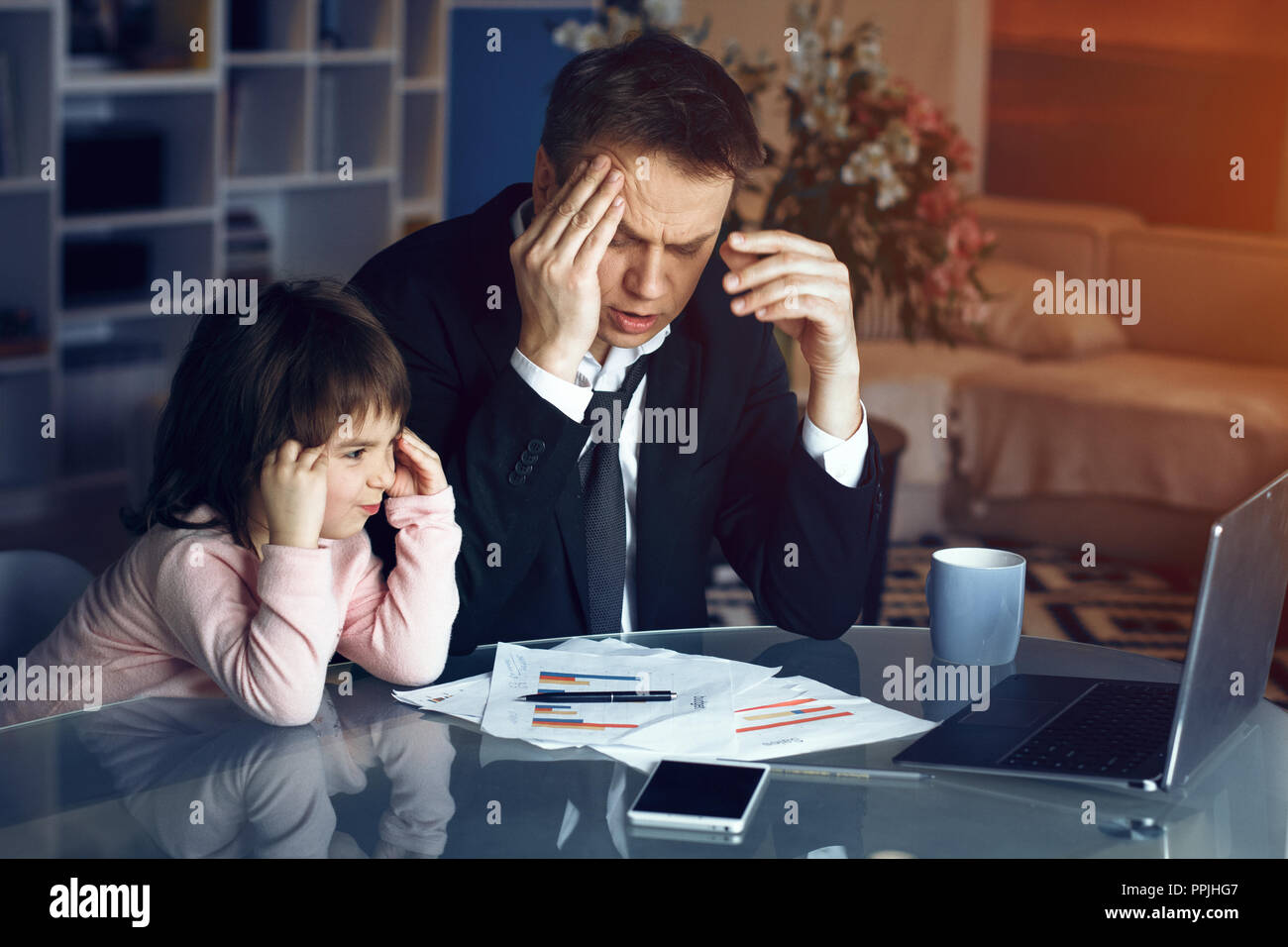 Daughter helping father working at home Stock Photo