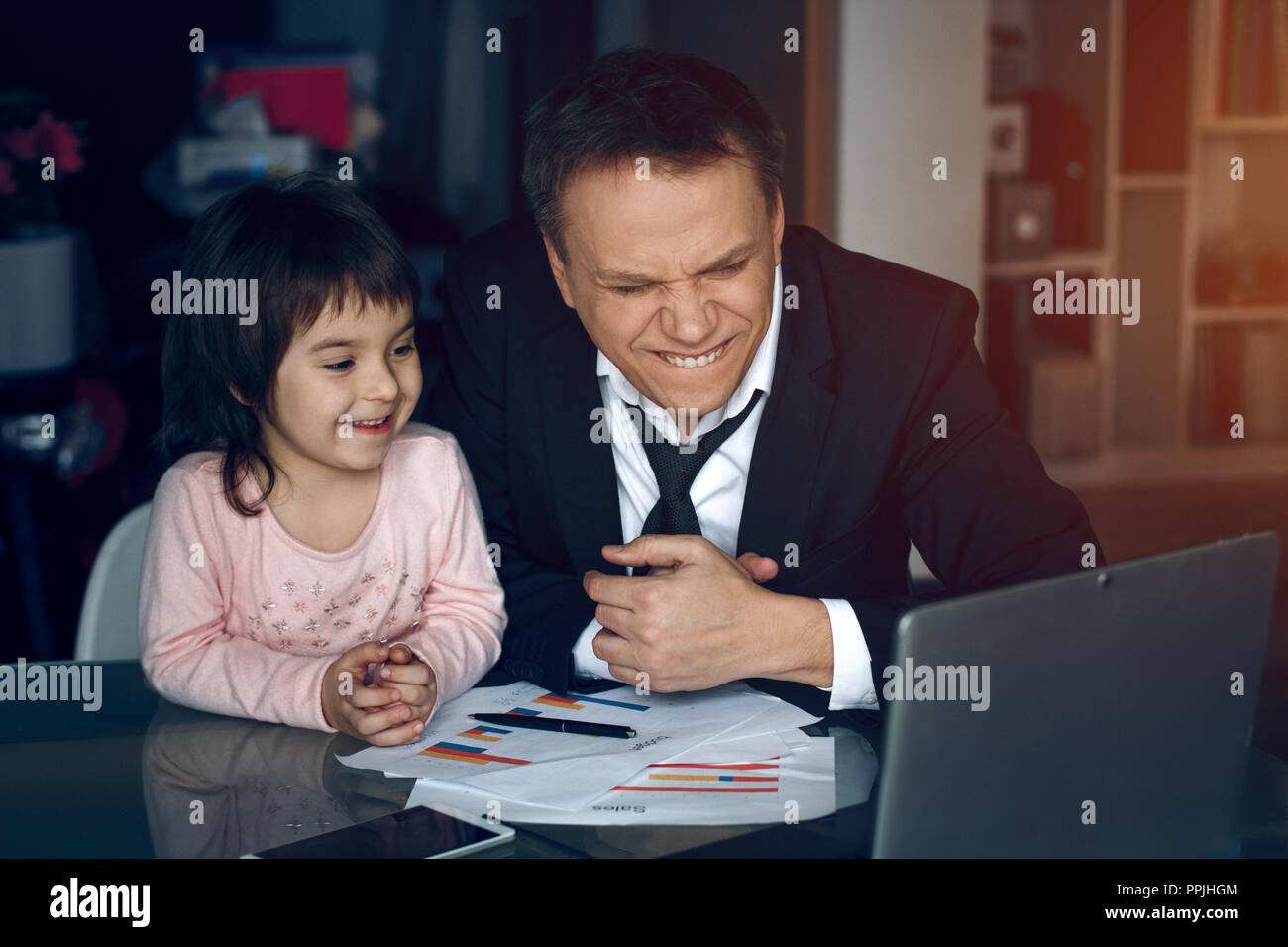 Daughter helping father working at home Stock Photo