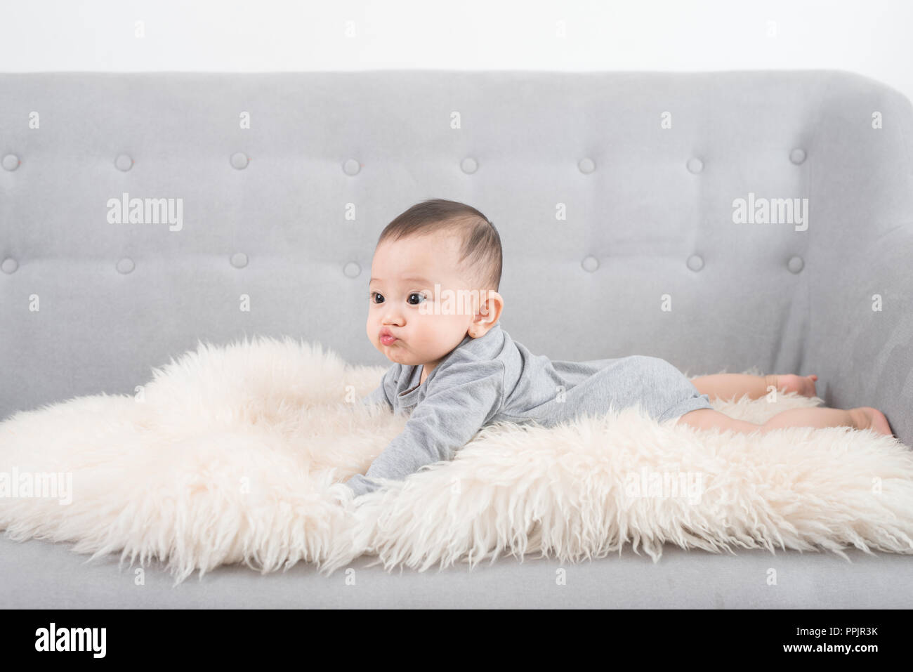 cute happy baby portrait lying on fur Stock Photo