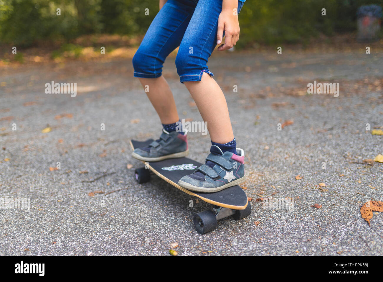 A child is skating on a longboard, close-up Stock Photo