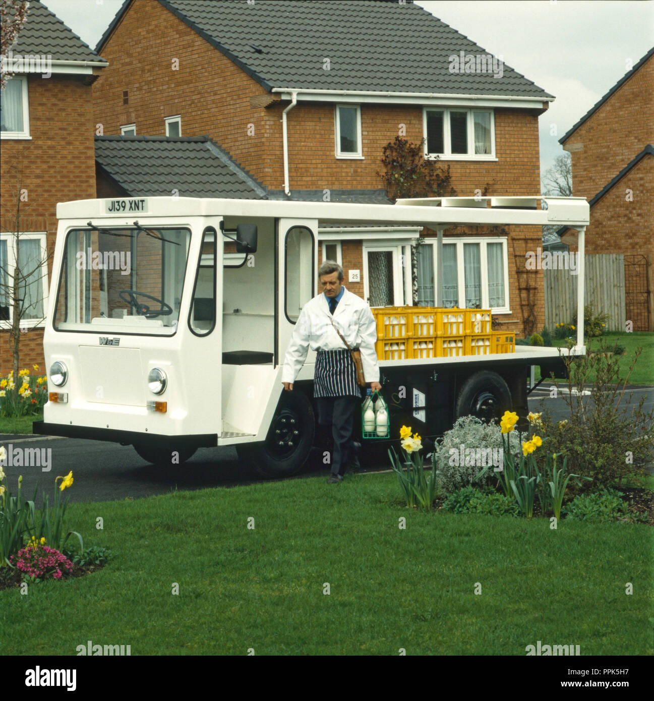 Doorstep milk delivery with milkman and milk float Stock Photo Alamy