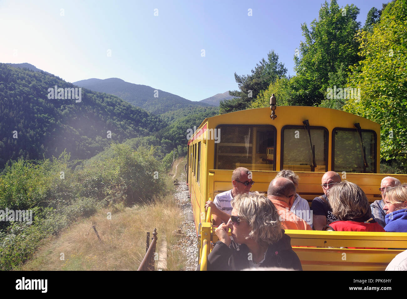 The small yellow trains of the Pyrenees crossing a beautiful mountain landscape Stock Photo