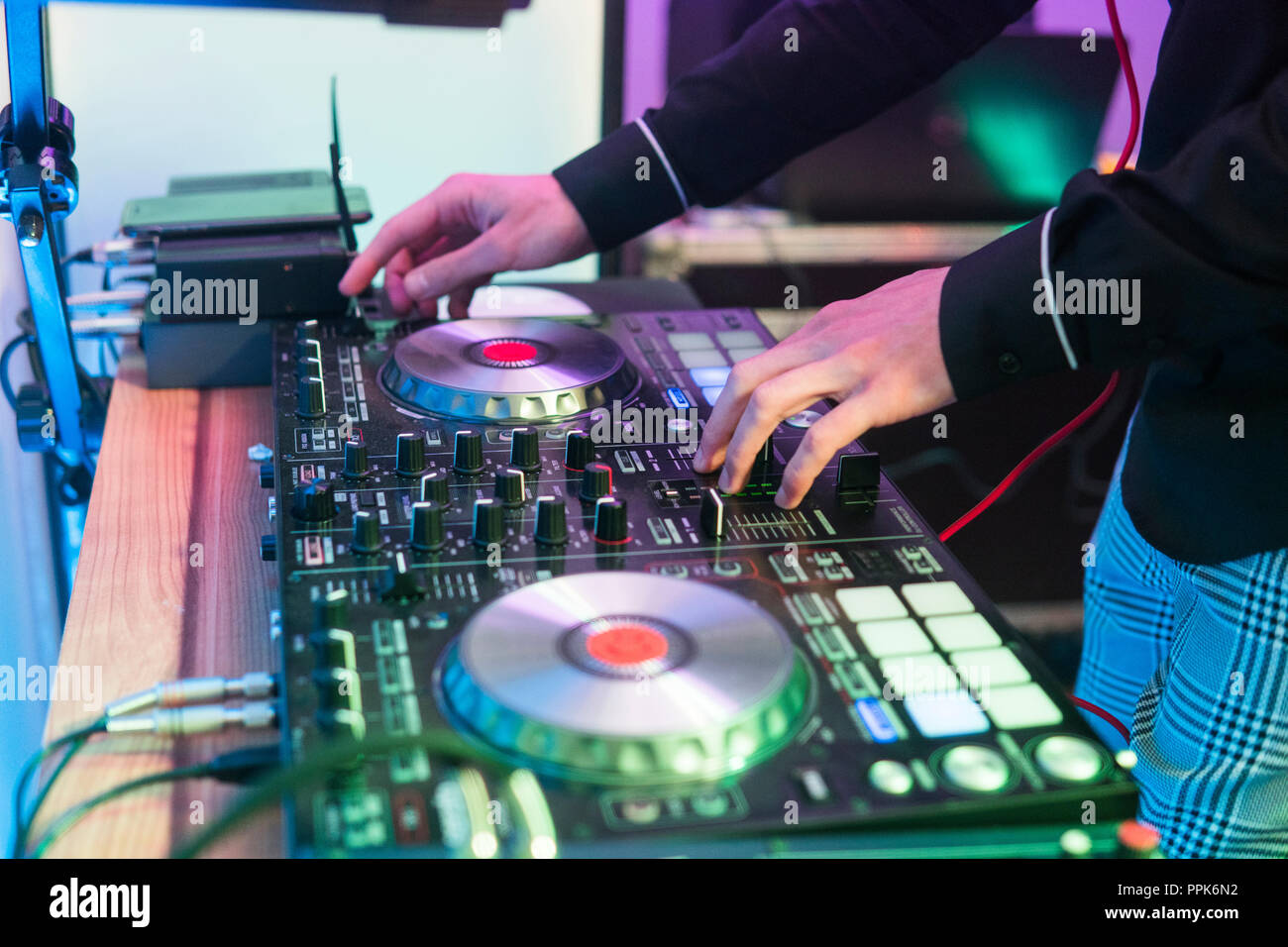 DJ plays and mix music on digital mixer controller. Closeup DJ