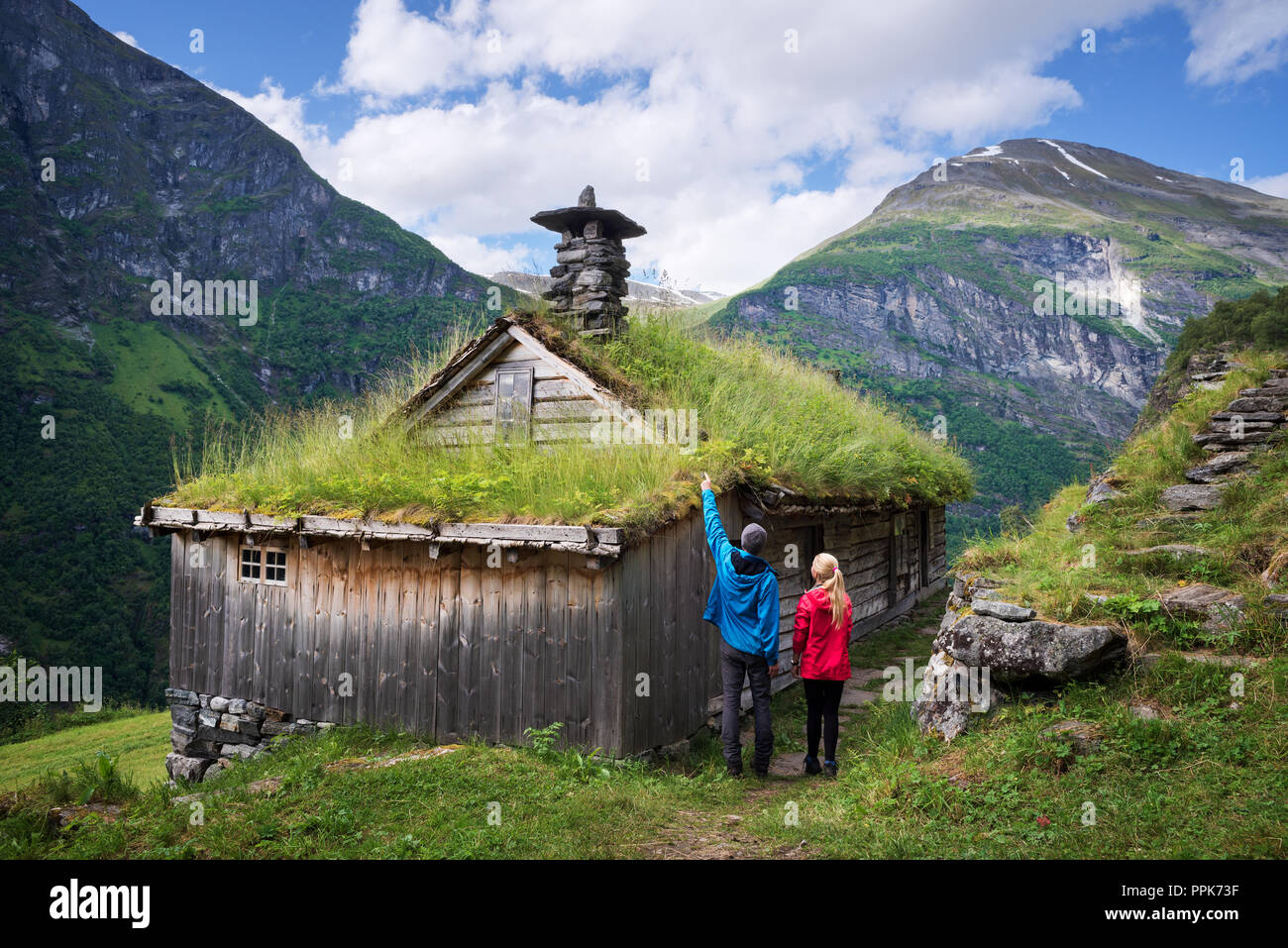 Kagefla - mountain farms with turf houses along the Geirangerfjorden fjord. Tourist attraction near Geiranger city, Norway. Travelers visiting traditi Stock Photo
