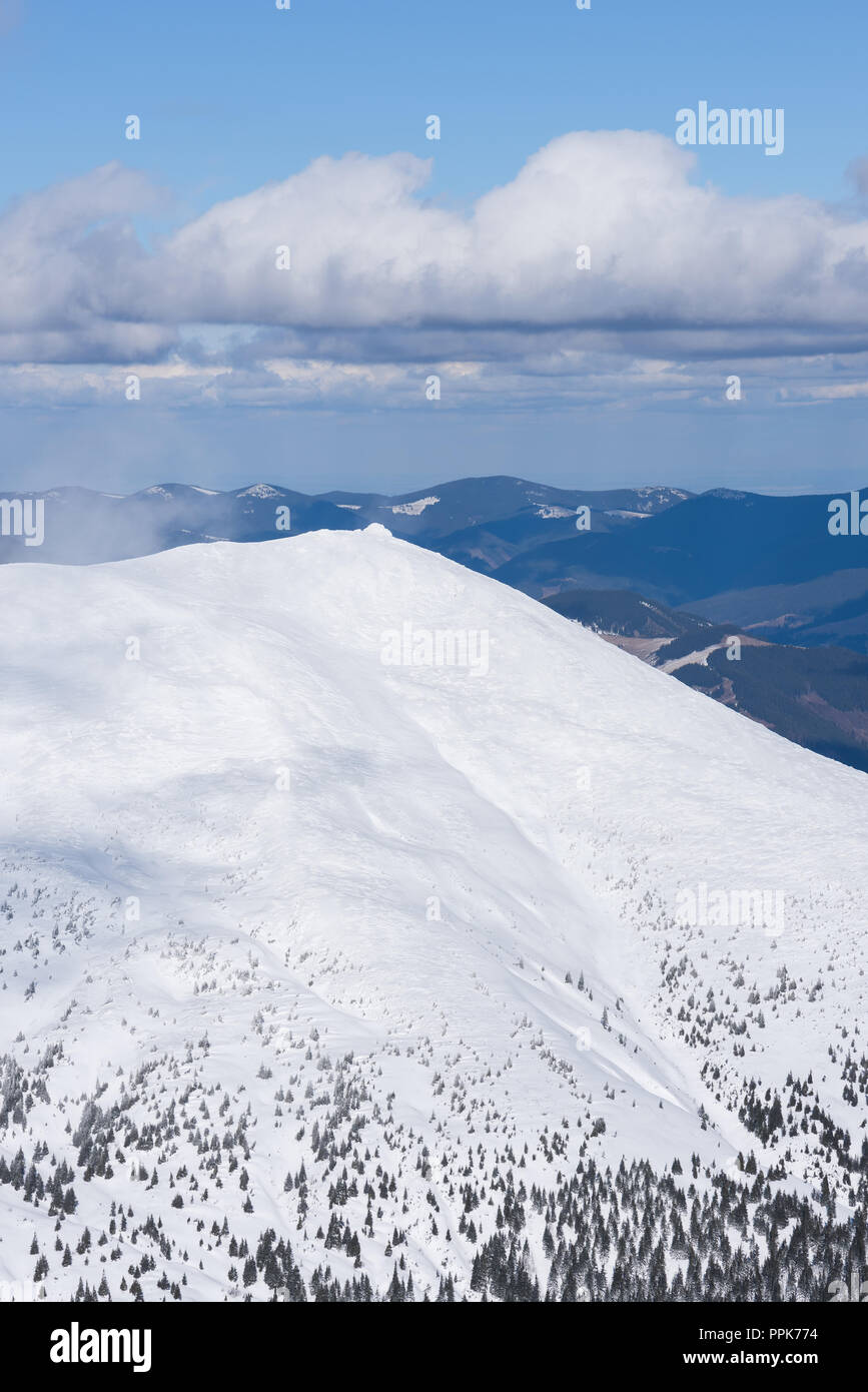 Snowy mountains in winter. Sunny weather with beautiful clouds. View of the ridge Stock Photo