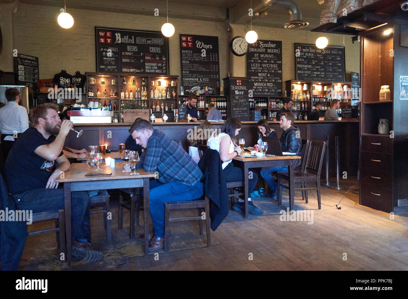 People enjoy a drink inside the popular restaurant and brewery in Glasgow  called WEST on the green Stock Photo - Alamy