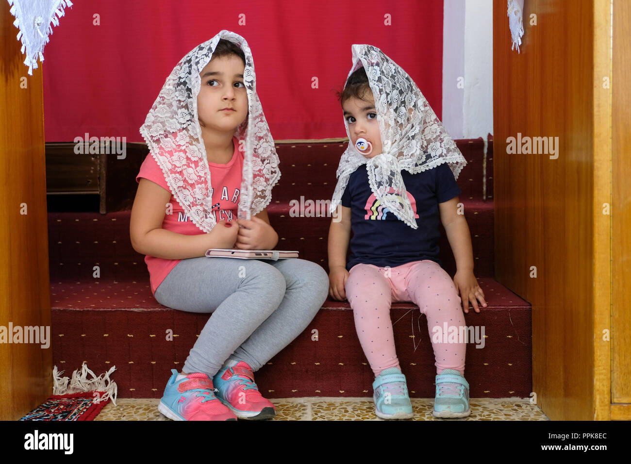 Two Christian children wearing a headscarf in a Syrian Orthodox church in northern Iraq, Kurdistan Region Stock Photo