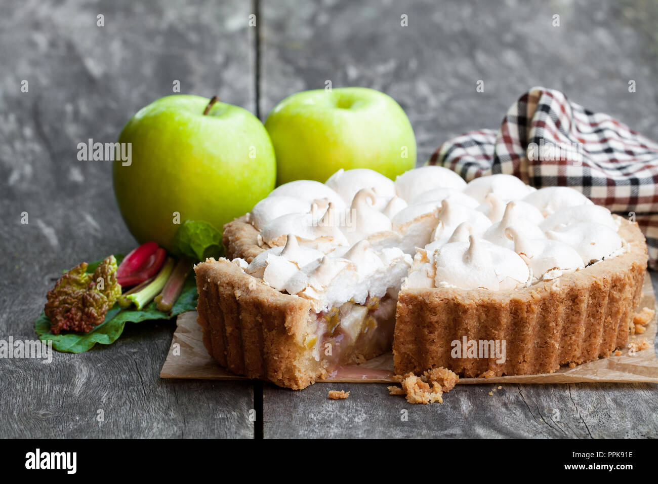 Tasty  meringue pie with rhubarb and apple on wooden table Stock Photo