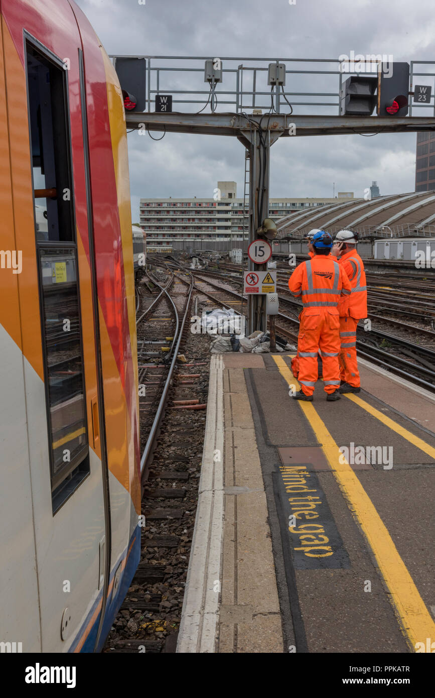 network rail workers and engineers on a platform fixing the track at