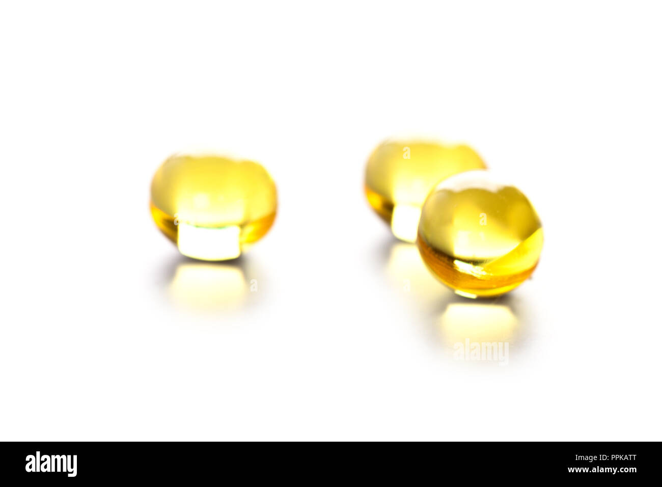 thre yellow gelatin pills on white background Stock Photo