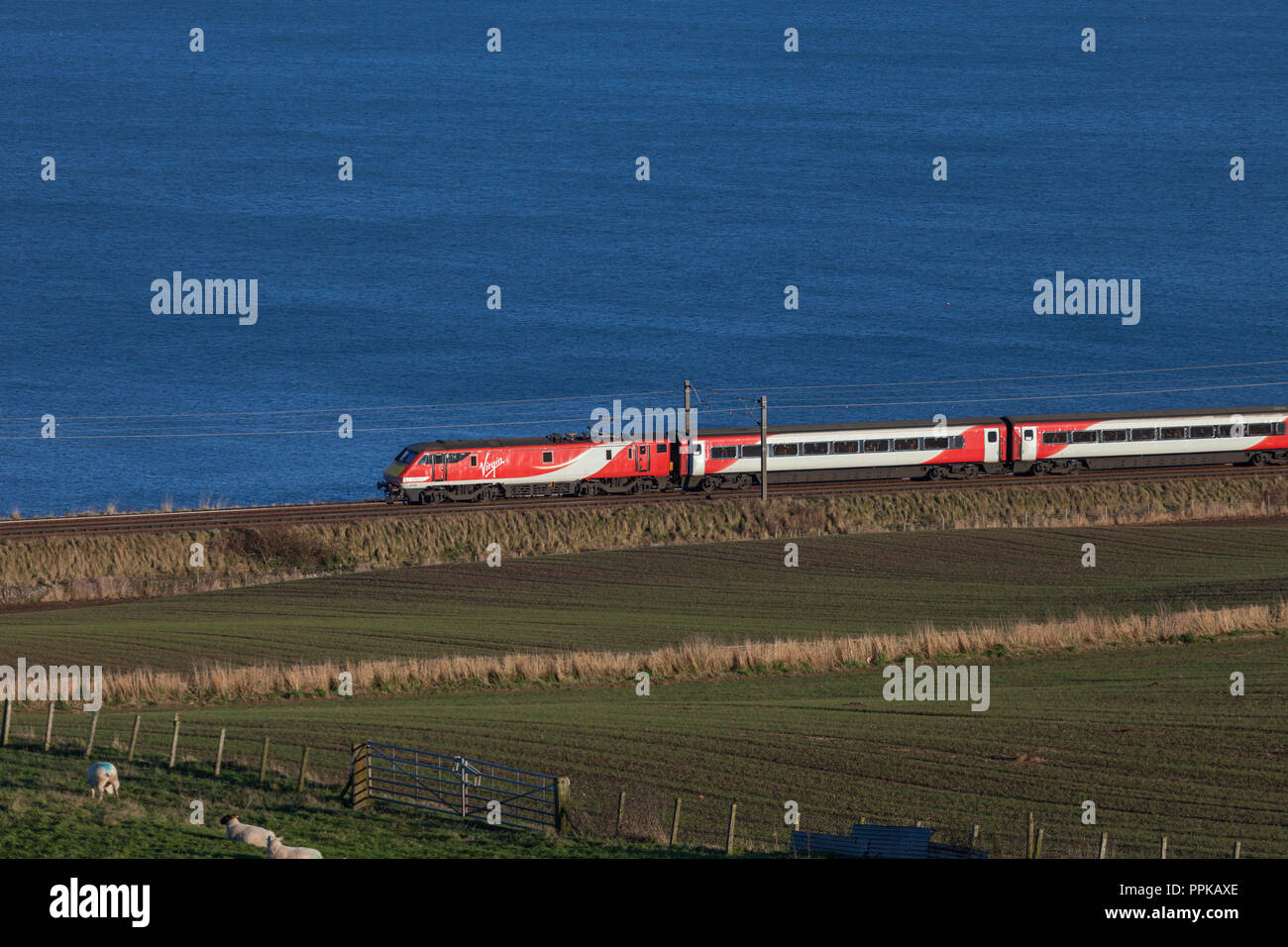 A Virgin Trains east Cast class 91 electric locomotive at Marshall meadows, about to cross the England / Scotland border on the east coast main line Stock Photo