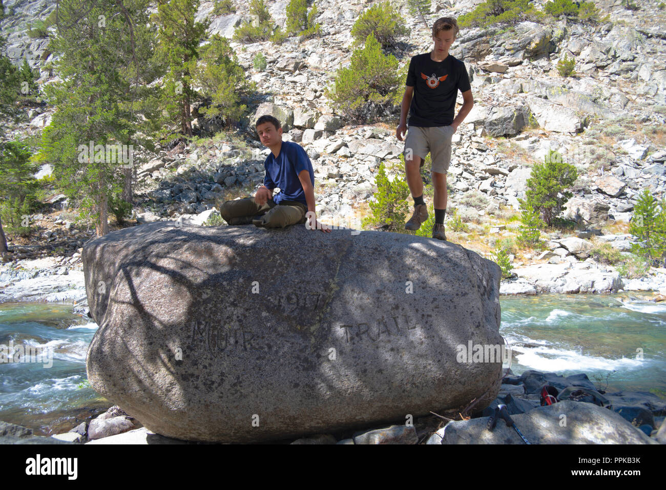 Two teenage boys atop famous John Muir Rock, along the John Muir Trail
