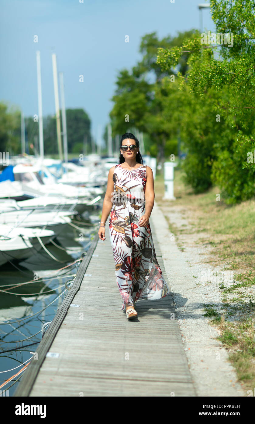 Stylish young woman walk on the pier.  Concept Summer Holidays Stock Photo
